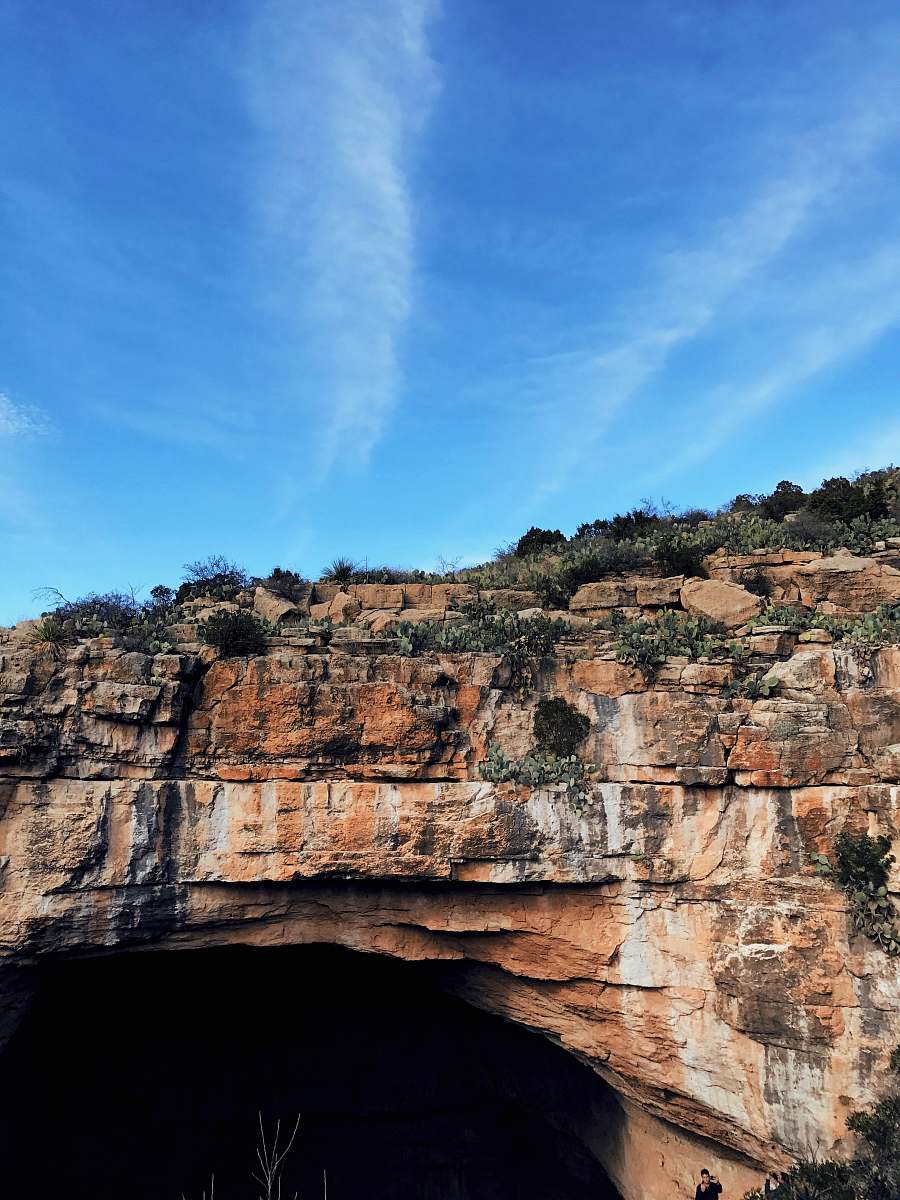 cliff green grass on brown stone formation carlsbad cavern natural entrance
